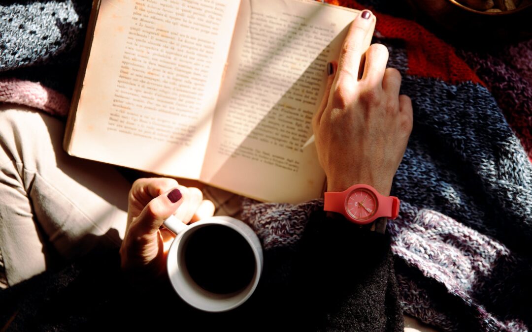 person reading book and holding coffee