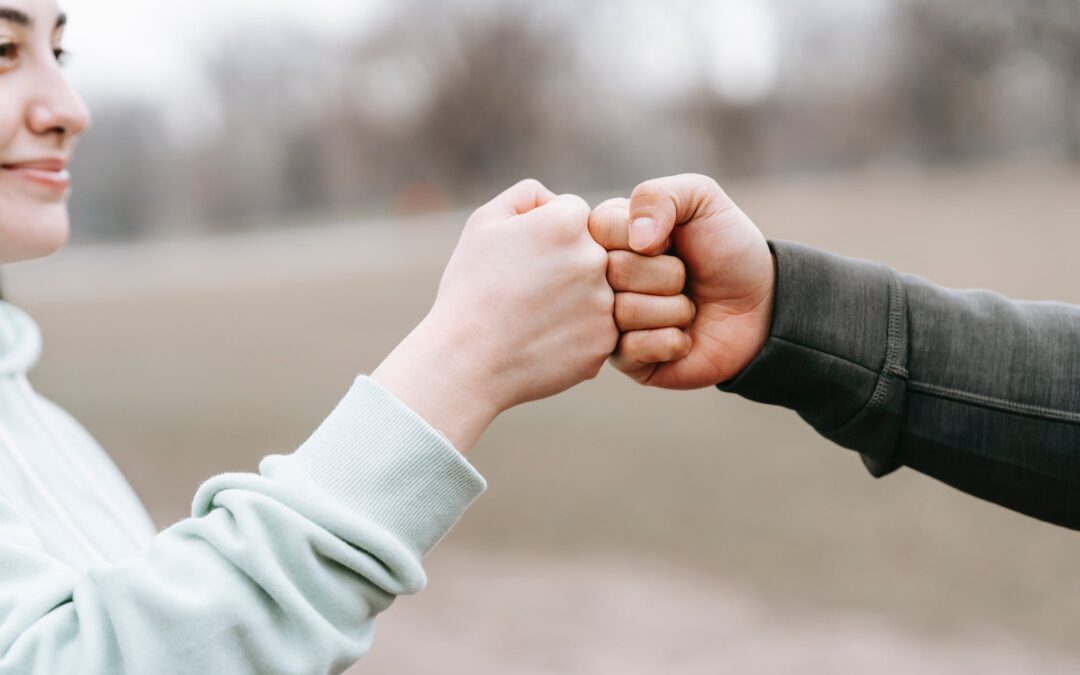 man and happy woman greeting each other with fist bump
