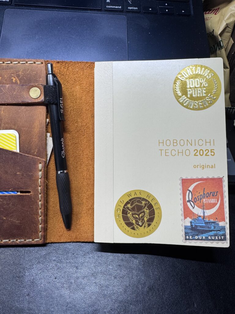 a personal daily log book hobonichi techo english language edition with stickers in a leather cover with pen