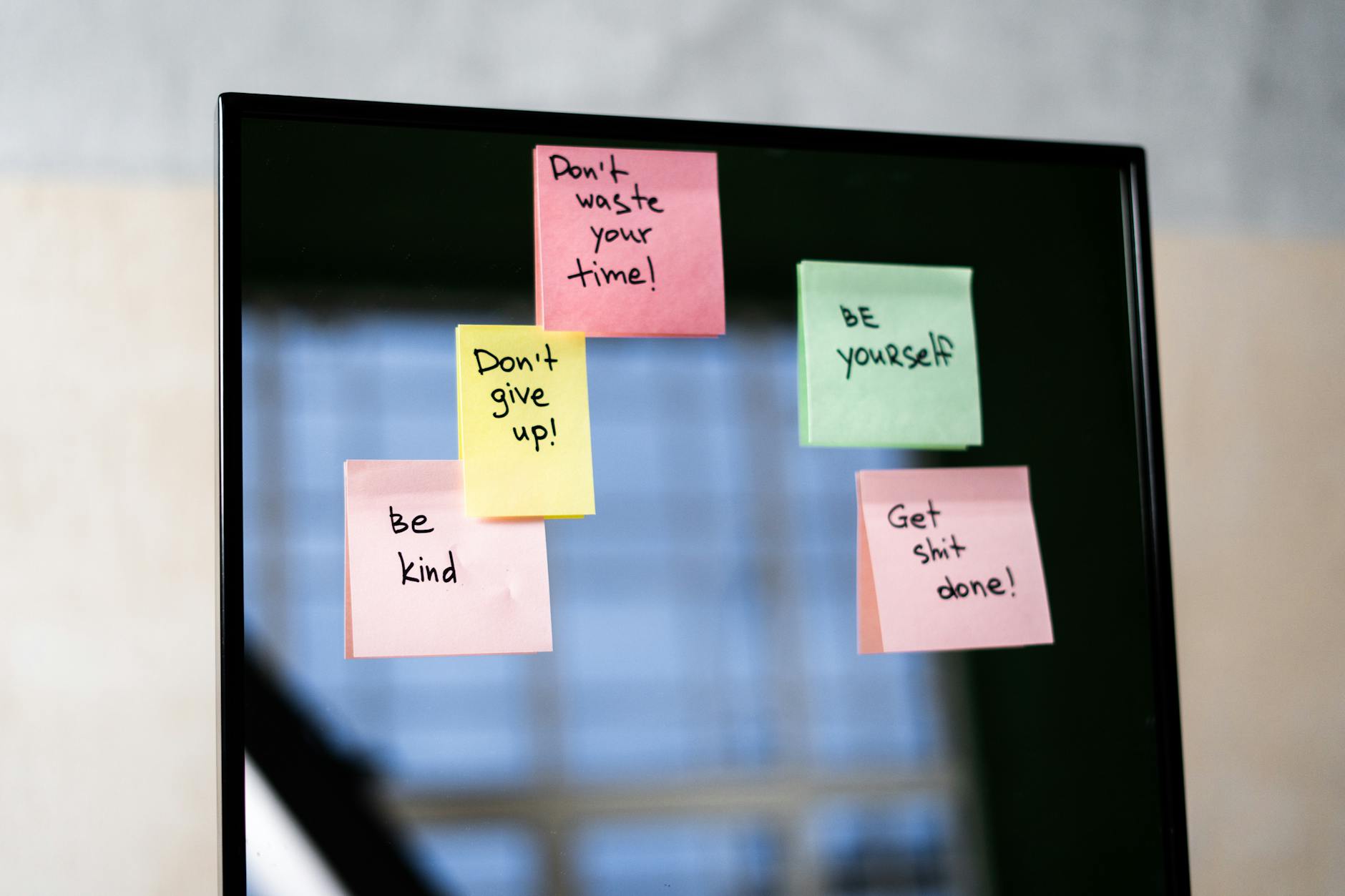 pink sticky notes on glass mirror