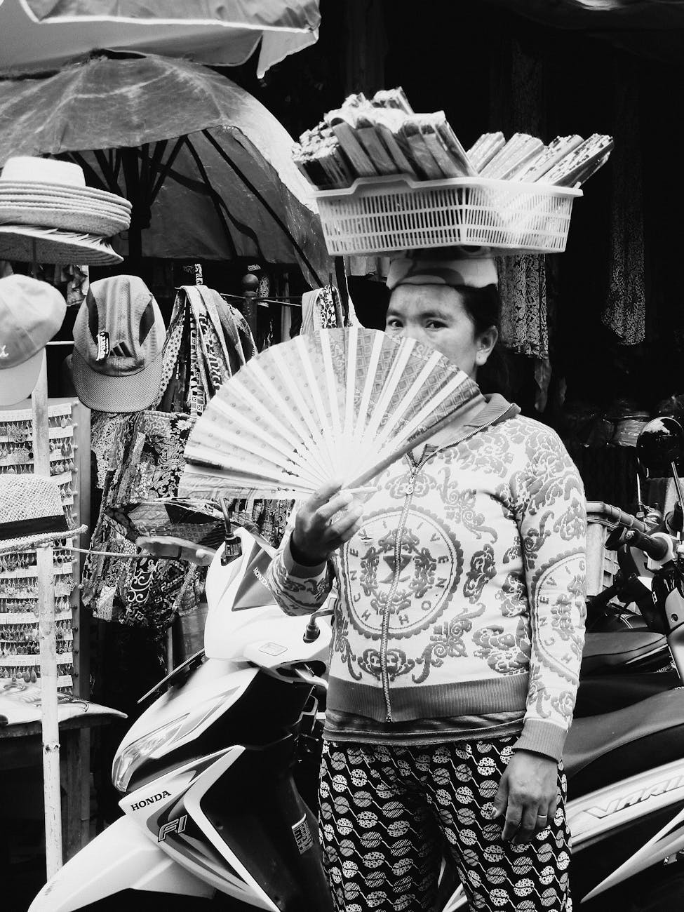 grayscale photo of woman holding fan
