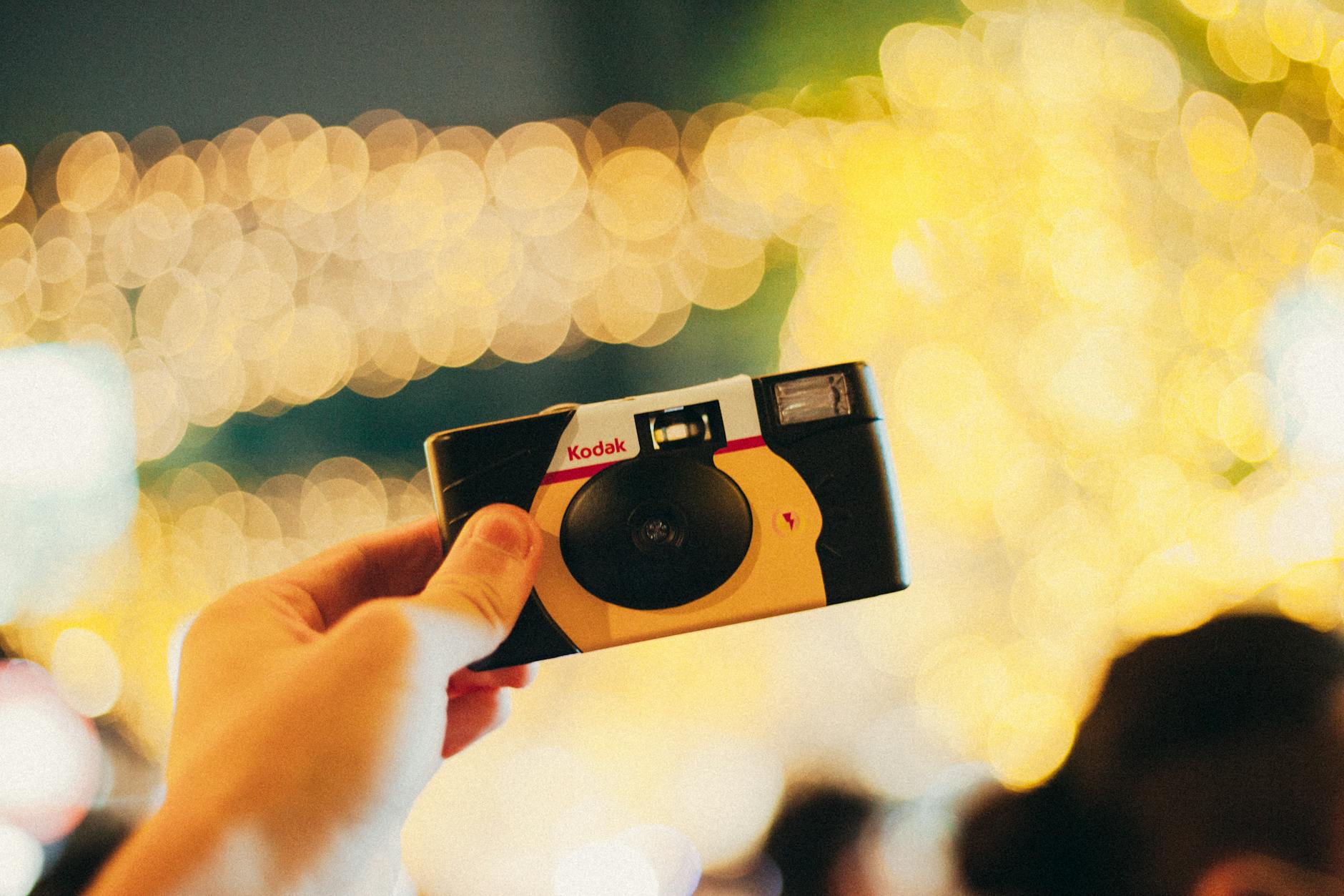 a person holding a kodak film camera